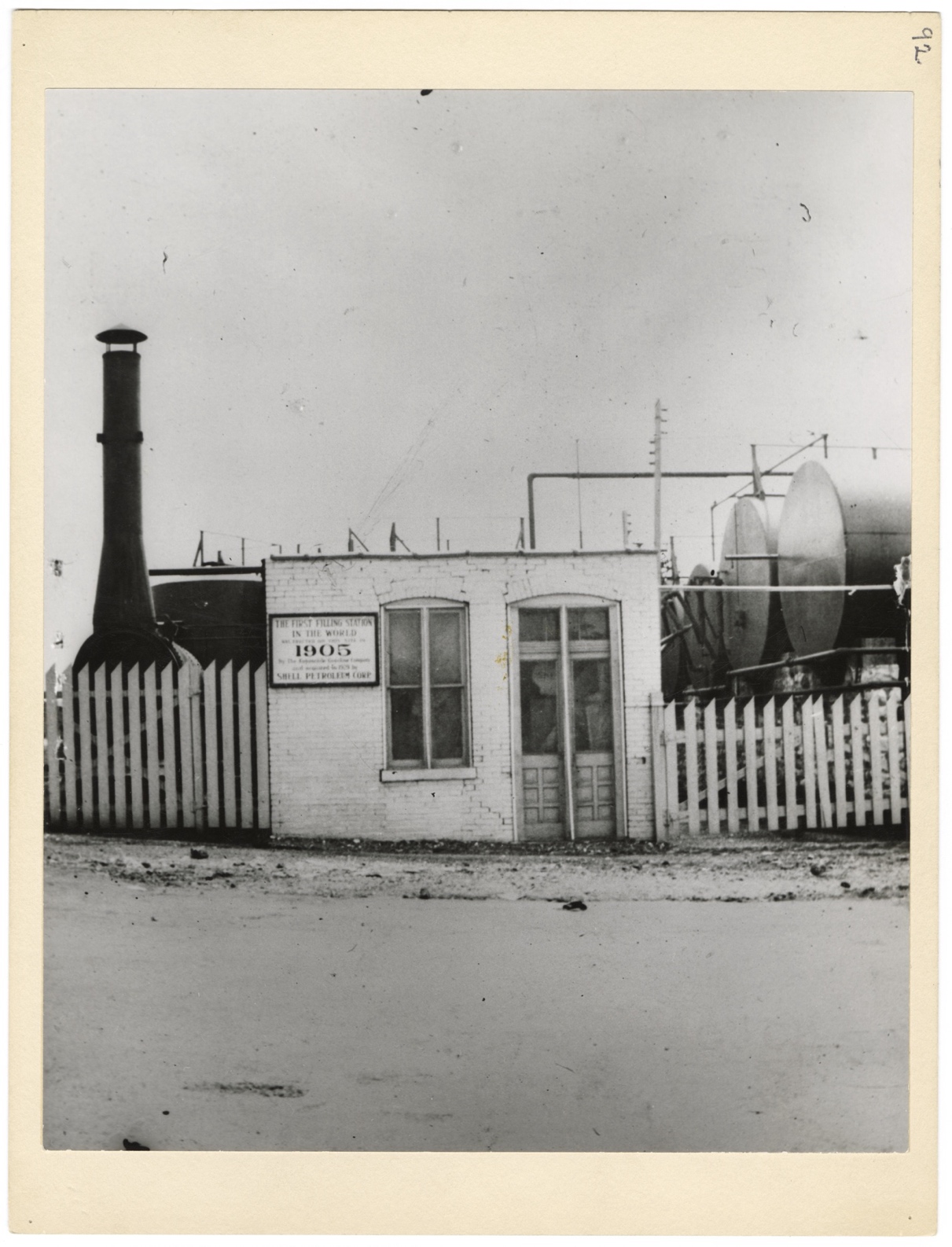 Image via the Missouri Historical Society. Sign on building reads, “First Filling Station in the World was erected on this site in 1905 by the Automobile Gasoline Co. and acquired in 1929 by Shell Petroleum Corp.”
